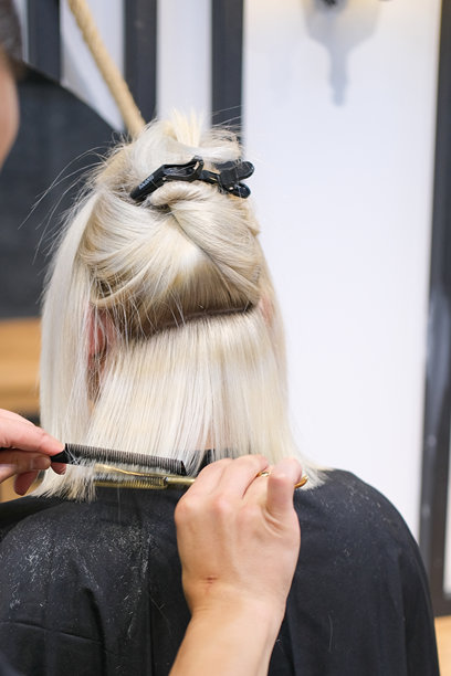 发型师在沙龙为年轻女性剪发的库存照片图片下载