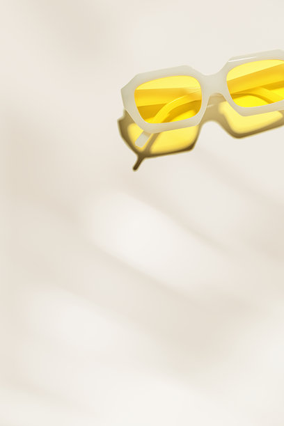 时尚的透明黄色太阳镜，背景为米色，留有空白，阳光下的阴影和眩光，夏季时尚的白色塑料框眼镜。极简美学生活方式照片图片下载