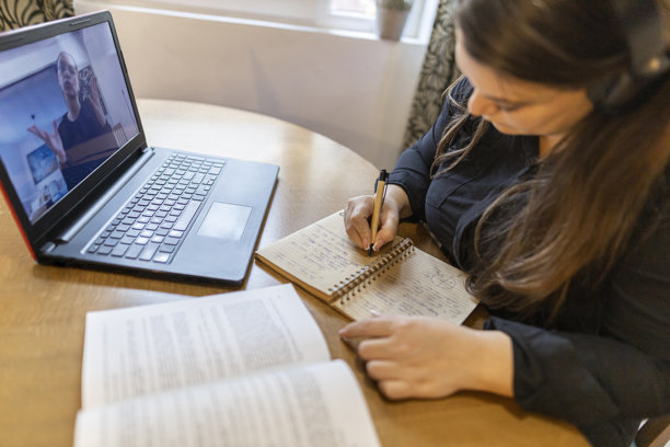 从上方拍摄的成年女性使用电脑的特写照片。在家办公室观看在线教育网络研讨会。图片下载