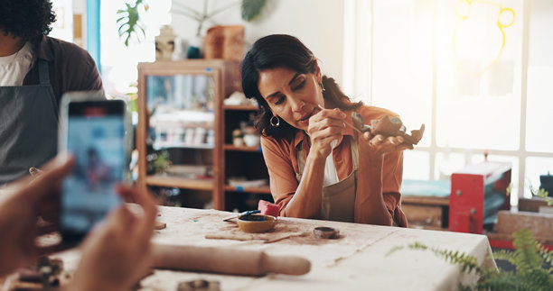 女性在陶土工作室中与陶器、图片一起，进行手工陶瓷设计的艺术过程。工艺、爱好和艺术家在创意课堂中进行作品创作和绘画，学习雕塑。图片下载