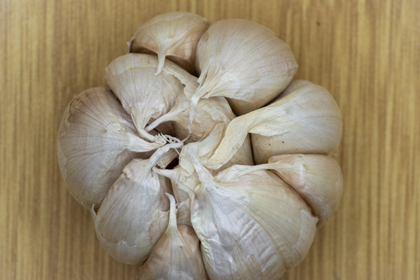 孤立的“白色”大蒜（Allium sativum）头部照片，背景为美观的竹子纹理。图片下载