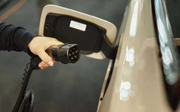 一只男人的手在电动车充电器上拿起一把枪的照片。图片下载