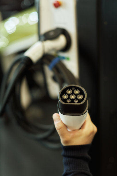 一只男人的手在电动车充电器上拿起一把枪的照片。图片下载
