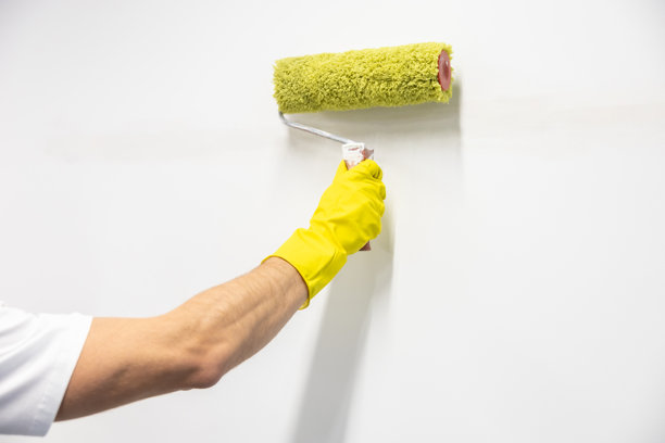 男人用滚筒给墙壁上色的特写照片图片下载