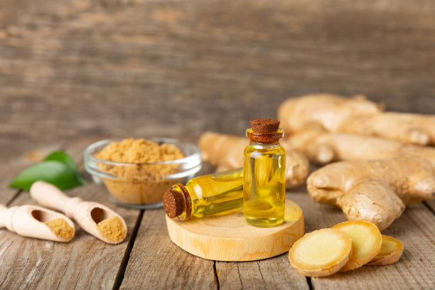 姜精油与纹理背景。新鲜姜片。精华，血清，油。替代医学。植物疗法。健康与美容概念。留白。图片下载