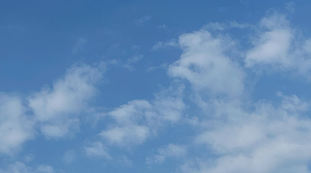 柔软的白云在生机勃勃的蓝天中漂浮。现代照片，白天的蓝光，适合作为网站、海报或横幅的优质背景。图片下载