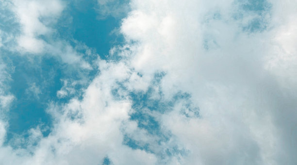 淡蓝色天空中漂浮着白云的照片。干净自然的现代背景，适合用作壁纸。图片下载