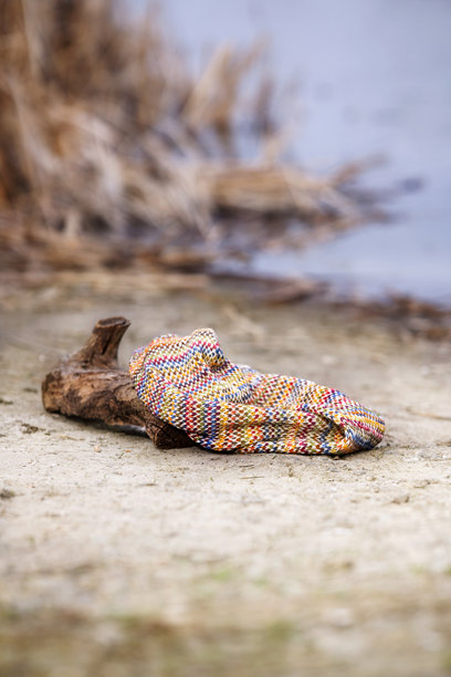 温暖背景的彩色羊毛围巾与自然背景的照片，艺术作品呈现柔和的暖色调。图片下载