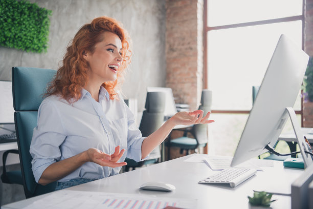 成功年轻女商人的个人资料照片，正在现代阁楼办公室内通过电脑进行视频通话。图片下载