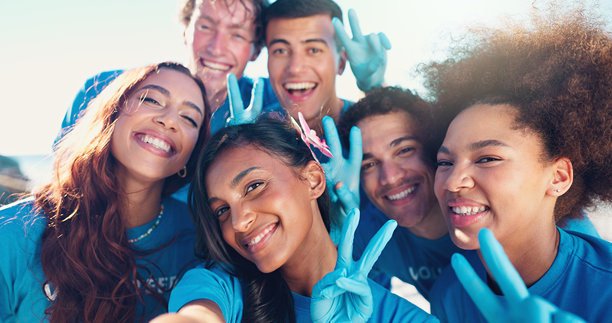 快乐的人们，肖像或志愿者做出和平手势自拍，社区服务或环保环境在海滩。团体、朋友或非政府组织团队的摄影、图片或记忆。图片下载