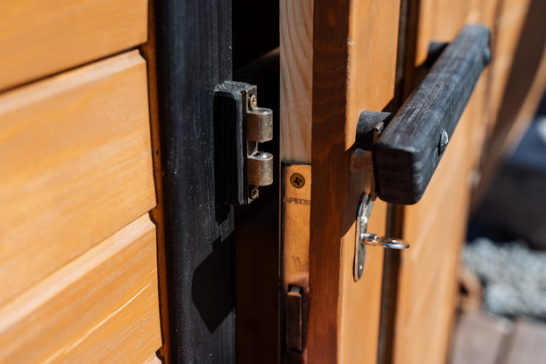 这张特写照片捕捉了一扇令人惊叹的木门的美丽，门锁中精致的钥匙恰好放置其中，突显了木材的卓越工艺和丰富纹理。图片下载
