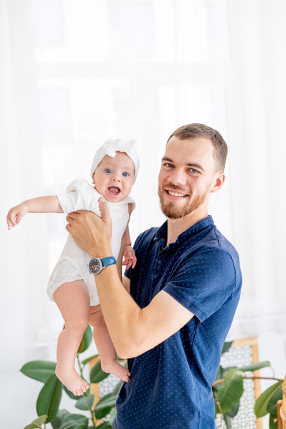 一个快乐的爸爸抱着他的小女儿，父亲身份的概念，带着宝宝在休产假的爸爸，爸爸和女儿的可爱照片图片下载