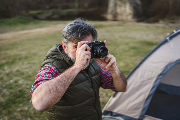 成熟男性在露营旅行中拍摄自然和风景的照片图片下载