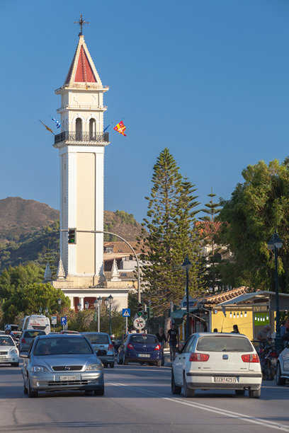 人们和汽车在扎金索斯港的海滨街道上，竖版照片图片下载