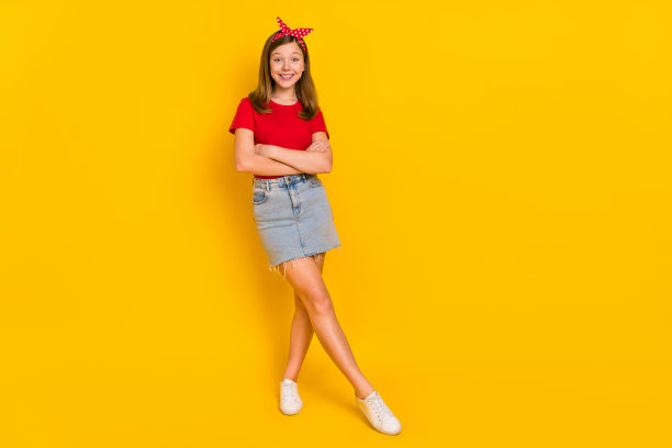 可爱迷人的小女人穿着复古风格的牛仔裙在黄色背景下摆姿势的全身照片图片下载