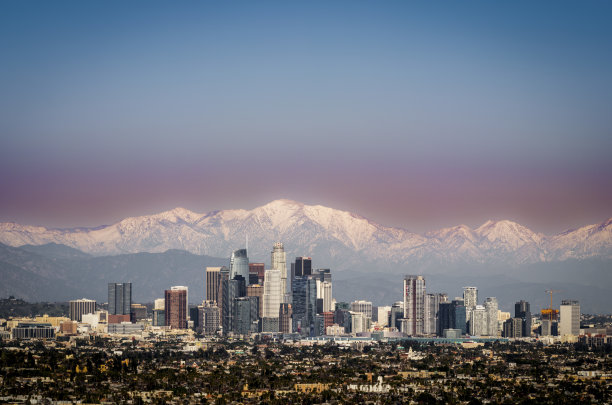 加利福尼亚州洛杉矶市中心的冬季照片，背景是白雪皑皑的山脉。图片下载
