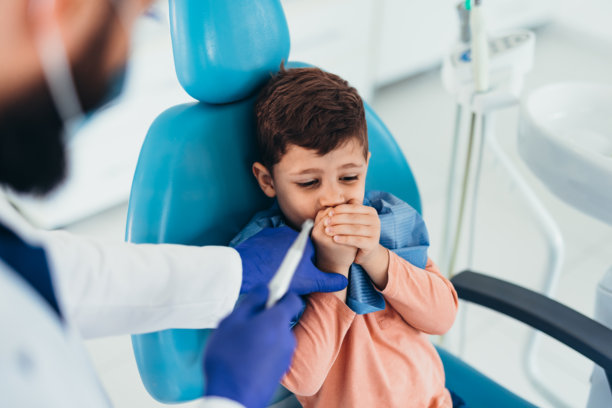 害怕的孩子在牙医那里捂住嘴巴图片下载