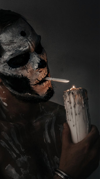 黑暗的照片中，骷髅人用蜡烛点燃香烟的身体艺术图片下载