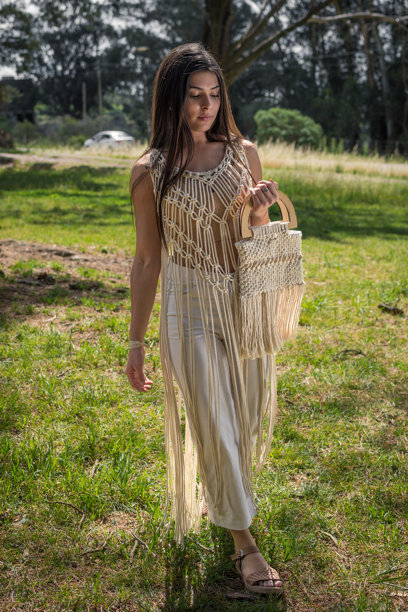 白天穿着针织裙的女性模特。街道和公园的竖版照片。图片下载