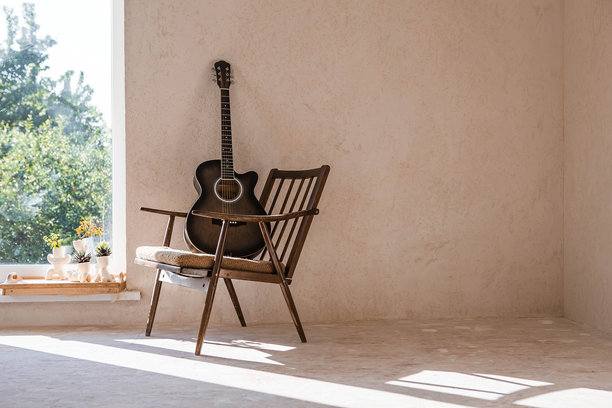 吉他。吉他和弦。木吉他。音乐。音乐背景。一张在有复古扶手椅的房间里拍摄的木吉他图片。强光。阴影。图片下载