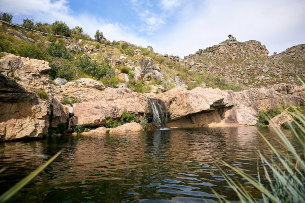 山中瀑布、坝或池塘的风景库存照片，四周环绕着自然和蓝天图片下载