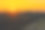 这张照片描绘了乡村风景下的绚丽日落。落日呈现为橙色天空中的明亮白色圆球。图片下载