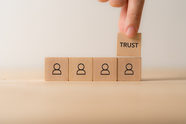 商业信任与成功概念。木块上刻有信任、团队合作、客户、商业伙伴图标。参与度与商业合作策略。企业价值观，商业成功策略。图片下载