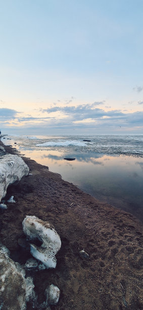 宁静的冰块在平静的海洋水面上日落时分。竖版照片图片下载