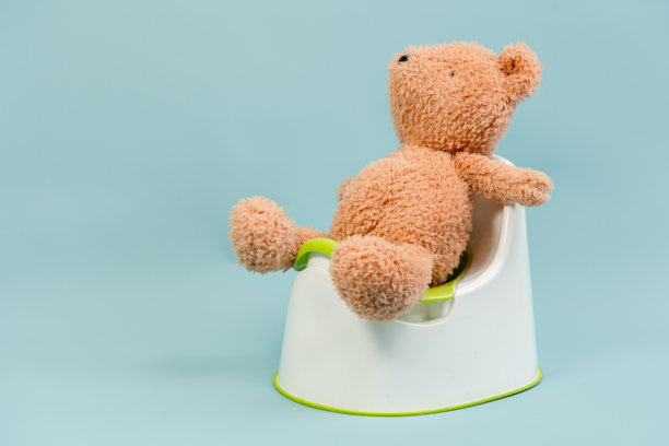 一个儿童玩具放在一个马桶上，背景简单，适合如厕训练。图片下载