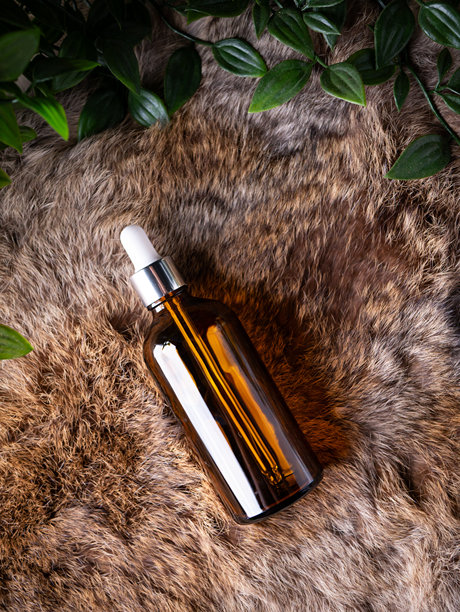 化妆品精华液、精油、草本香疗油的滴管瓶，置于深色背景上。图片下载