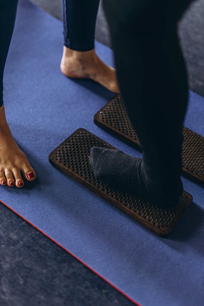 在钉子上站立。年轻女性在大自然中练习瑜伽和疗法。高质量照片图片下载