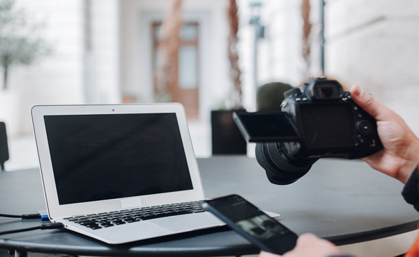 摄影师在设备上检查照片，确保质量并挑选最佳镜头进行编辑和后期制作。图片下载