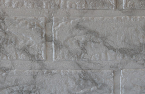 这张图片展示了一个类似大理石的浅色砖石表面的特写。主要颜色是浅灰色，表面有深灰色的纹理或大理石图案。纹理不规则，具有微妙的高度变化。图片下载