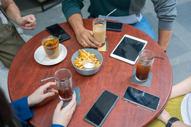 特写咖啡桌，上面放着智能设备和饮品的库存照片图片下载