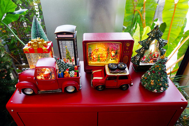 圣诞玩具装饰在桌子上，卡车里的圣诞老人和电视里的圣诞老人，以及旁边的圣诞树图片下载