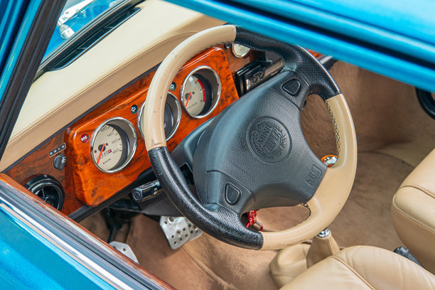 这张图片展示了一辆经典汽车驾驶员侧的内饰，显著的方向盘上有多个仪表和指示器，包括速度和燃油表 - 乌克兰基辅 2024年6月6日图片下载