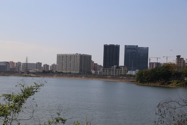 从中国的城市的工业区对面俯瞰河流，一侧是高楼大厦和现代办公楼。图片下载