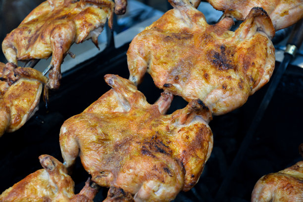 火上的鸡肉。鸡肉烧烤。餐厅中烤箱里的烤鸡，特写照片。烟熏中的烤鸡。快餐。图片下载