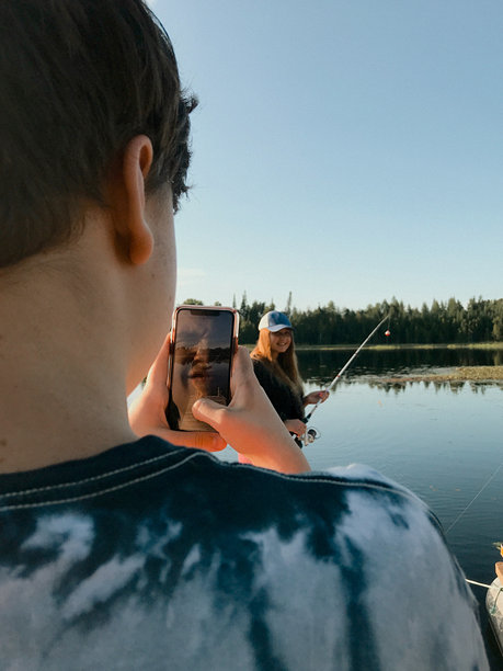 少年男孩第一次给女朋友拍钓鱼的照片。图片下载