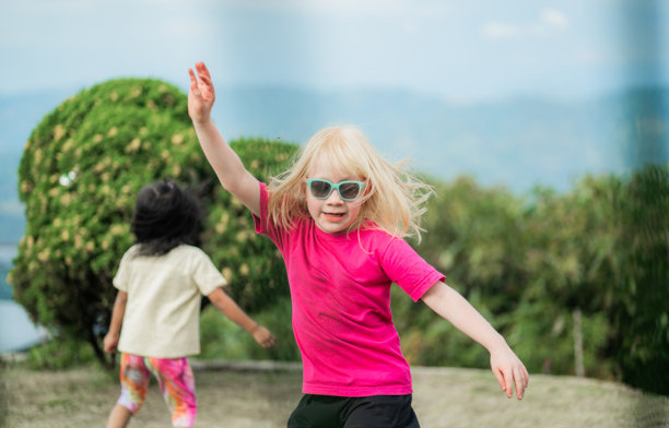 两个不同民族的女孩在公园里玩耍 - 股票照片图片下载