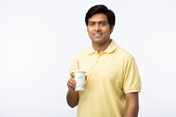 年轻男子在白色背景下喝果汁的库存照片图片下载