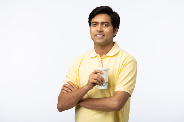 年轻男子在白色背景下喝果汁的库存照片图片下载