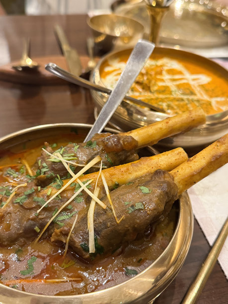 印度餐厅菜肴的图片 / 咖喱炖羊肉配马萨拉罗根，盛在金色盘子里 / 美味的传统印度美食，丰富的香料图片下载