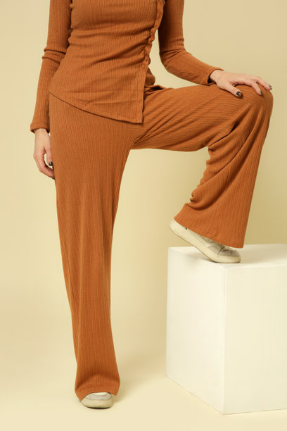 女性模特穿着基本舒适的金棕色针织套装的工作室照片，秋冬时尚系列。图片下载