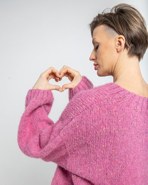 快乐女性的肖像。女性用手指做出心形手势。竖版照片图片下载