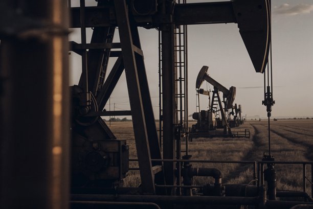 黄昏时分广阔田野中的石油钻井平台。高质量照片图片下载