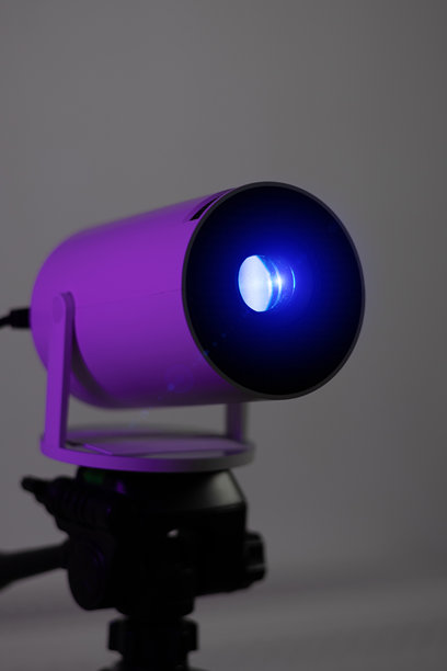 现代Wi-Fi投影仪镜头的垂直照片，发出蓝色光线。适合视频或照片展示以及家庭电影观看。图片下载