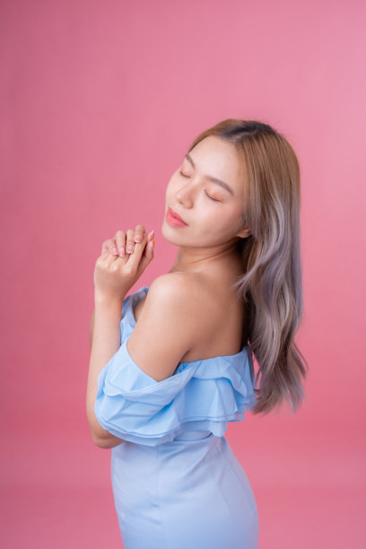 这张构图精美的女性模特工作室照片以柔和的粉色背景为特色，旨在吸引高端广告或现代网站界面的注意。图片下载