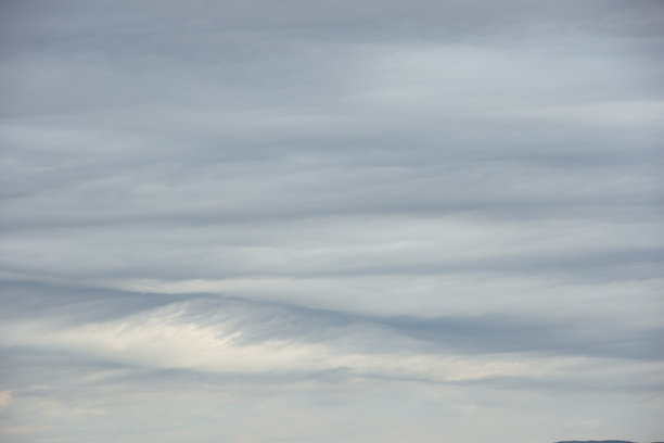密集的灰色雷暴积云波浪状云层覆盖整个画面。阴沉的雨天天空背景，可用于叠加在您的照片上。图片下载