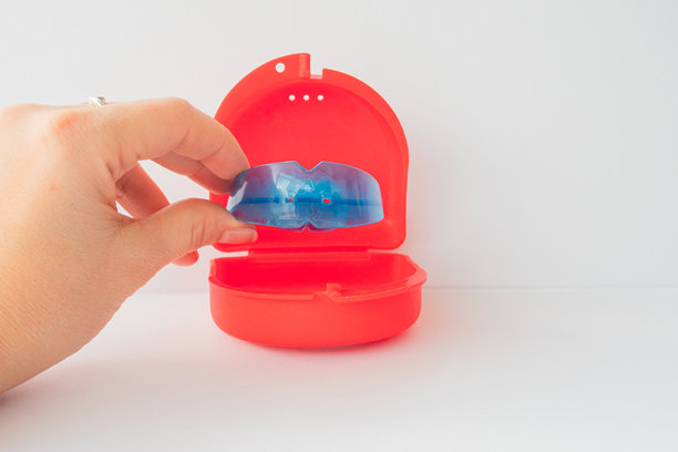 手持牙齿矫正模拟器进行牙齿对齐。牙科训练器调整生长中的牙齿，矫正咬合，青少年和儿童正畸口腔健康护理概念。护齿器，牙套。图片下载